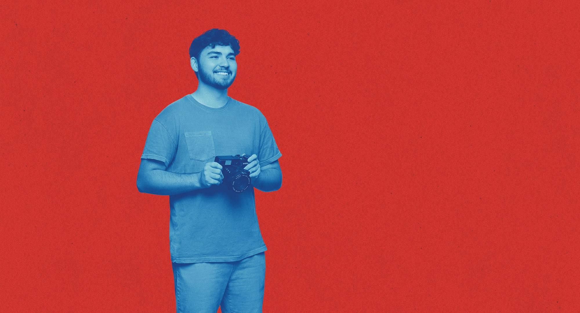 Student colored in blue filter standing in front of a red background.